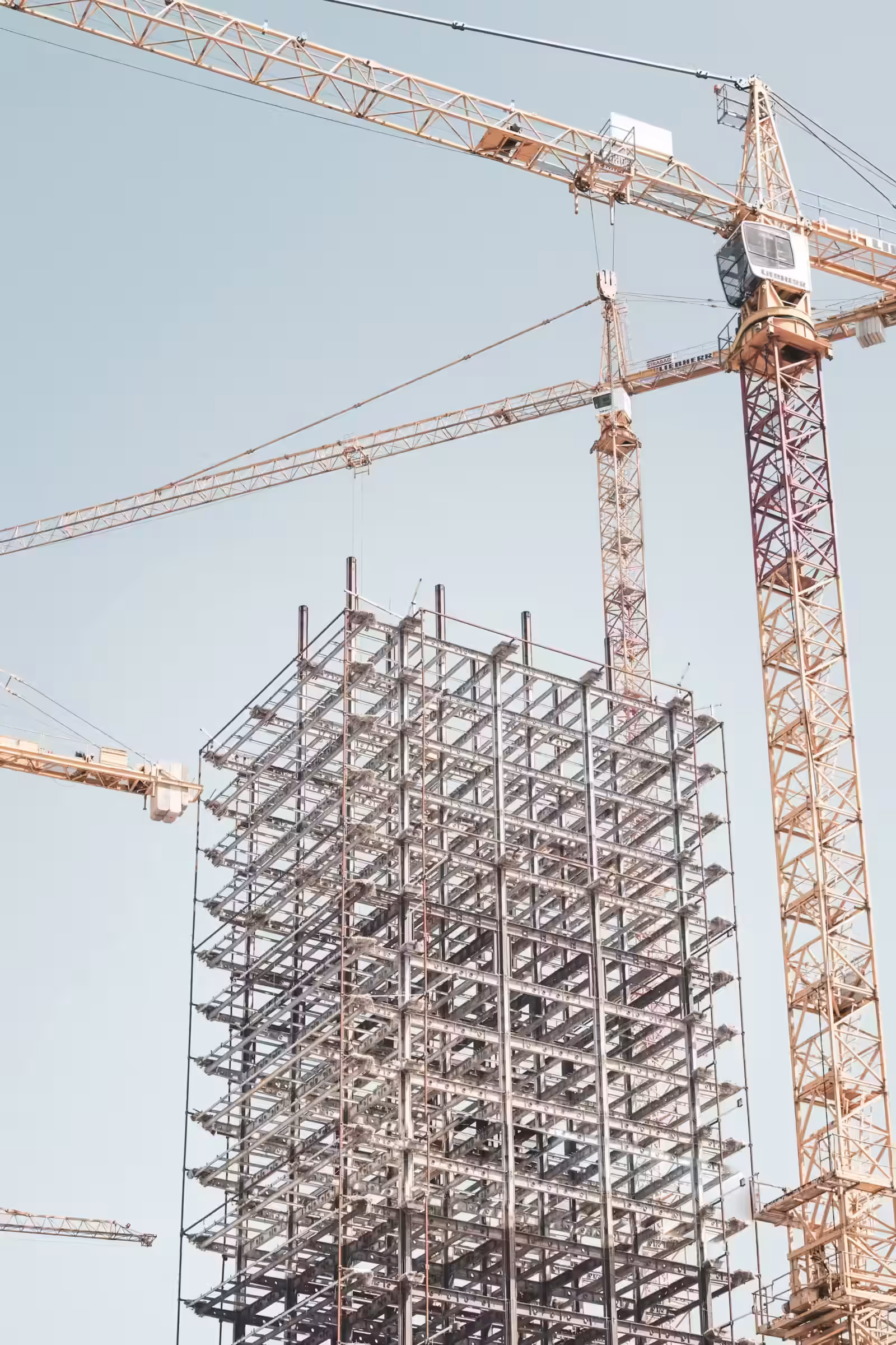 Structure métallique grise d'un bâtiment près d'une grue à tour pendant la journée
